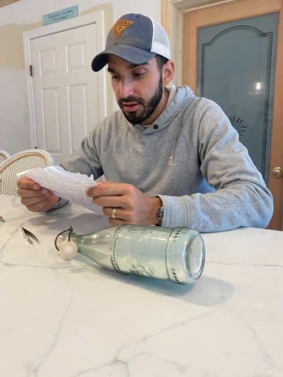 Ben Klein reads the letter found on Martha's Vineyard. (Dorey Scheimer/WBUR)