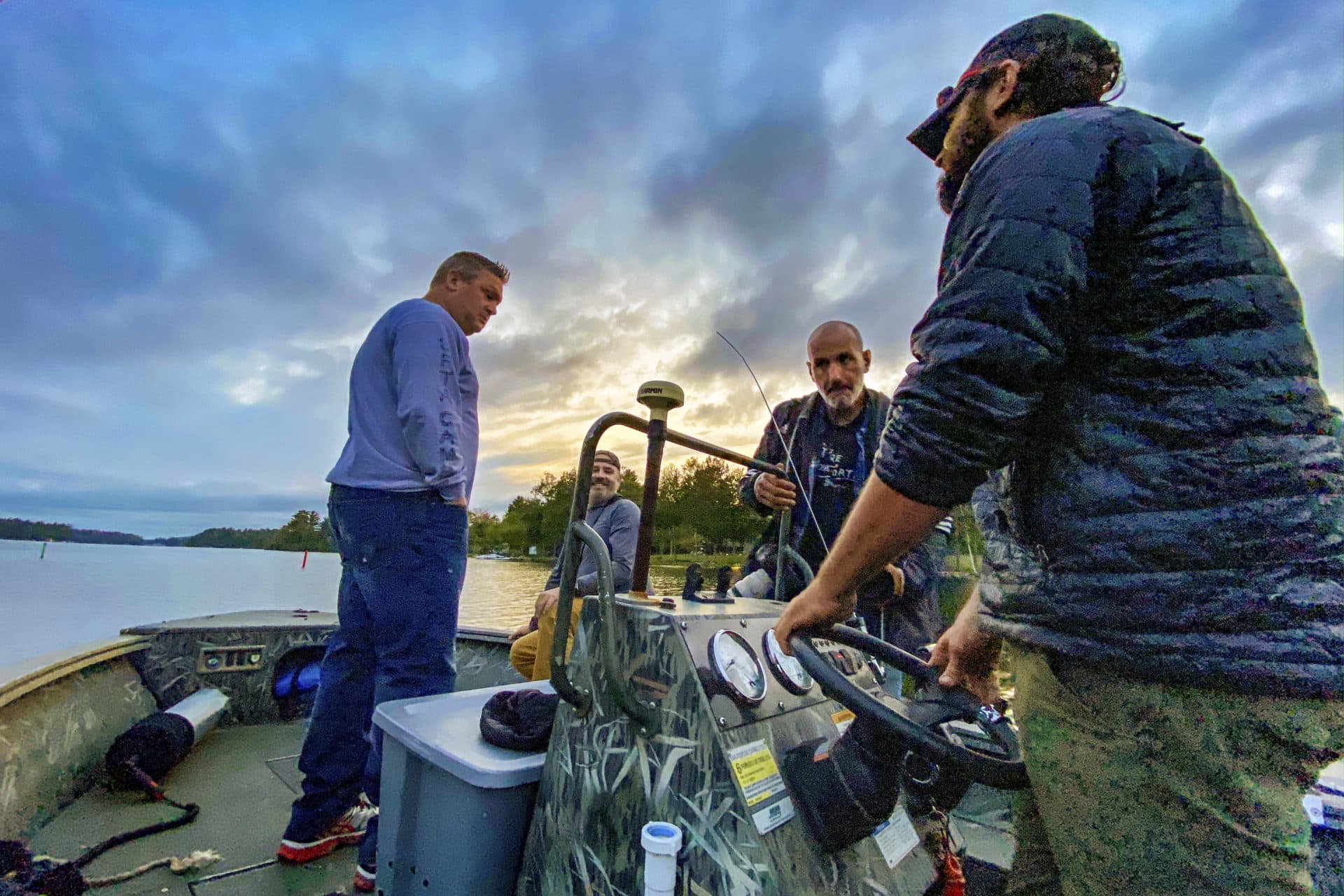 WBUR photographer Jesse Costa (second to right) heads out with the team for a loon capture on Woodbury Pond in Litchfield, Maine. (Miriam Wasser/WBUR)
