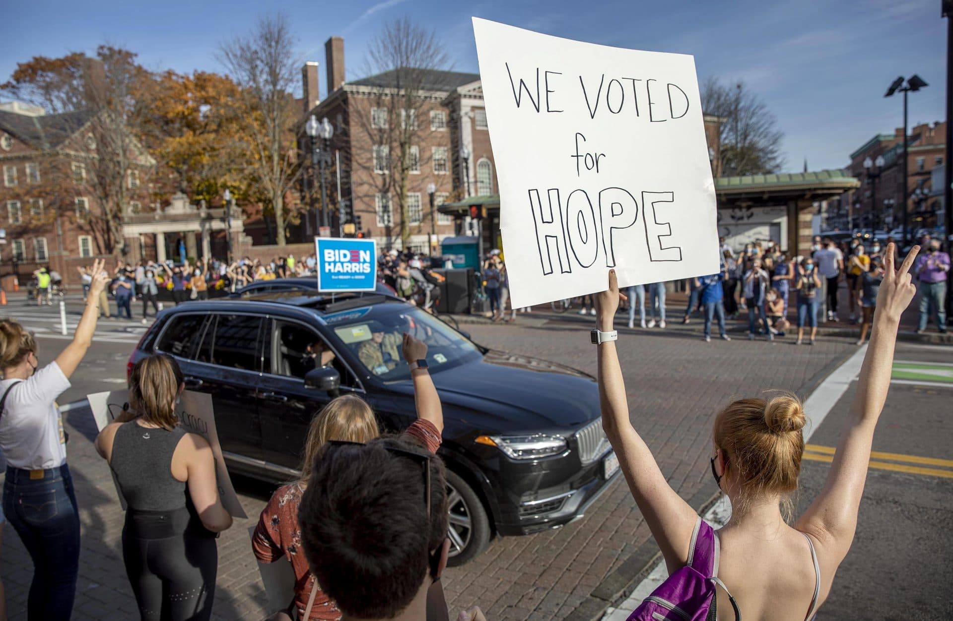 A woman holds up a sign saying "We Voted For Hope" as the crowd in Harvard Square celebrates Biden's election. (Robin Lubbock/WBUR)