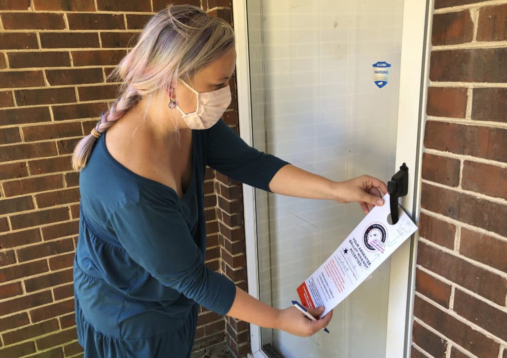 Christin Clatterbuck leaves an affidavit and information about fixing absentee ballots on the door of a home in Stone Mountain, Ga., Friday, Nov. 6, 2020. (Sudhin Thanawala/AP)