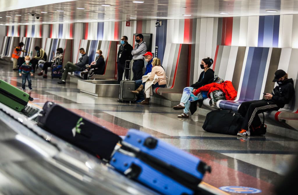 People wait for their baggage at Boston Logan International Airport in Boston on Nov. 25, 2020. The  airport was bustling with travelers on the Eve of Thanksgiving, despite people being encouraged to stay home. (Erin Clark/The Boston Globe via Getty Images)