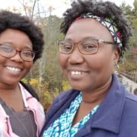 I'm staying home alone this year, writes Theresa Okokon. But I'll pretend my mom is watching TV with me. In this photo, the author is pictured with her mother (Courtesy)