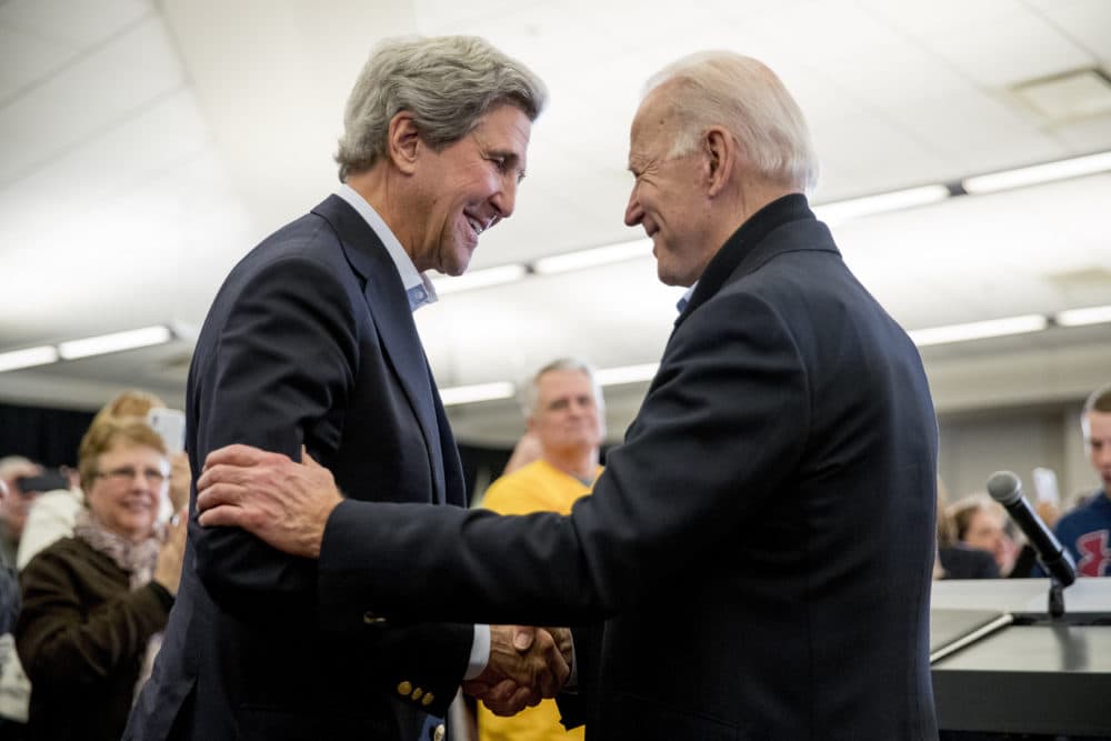 In this Feb. 1 file photo, Joe Biden smiles as former Secretary of State John Kerry, left, takes the podium to speak at a campaign stop at the South Slope Community Center in North Liberty, Iowa. (Andrew Harnik/AP)