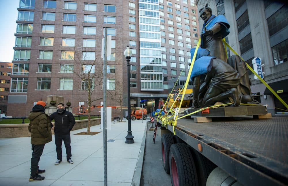 Raul Fernandez, right, and Tory Bullock discuss the removal of "Emancipation Group" after it was removed from its pedestal in Park Square Tuesday morning. (Jesse Costa/WBUR)