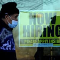 A shopper wears a face mask and he walks past a store displaying a hiring sign in Wheeling, Ill., Nov. 28, 2020. (Nam Y. Huh/AP)