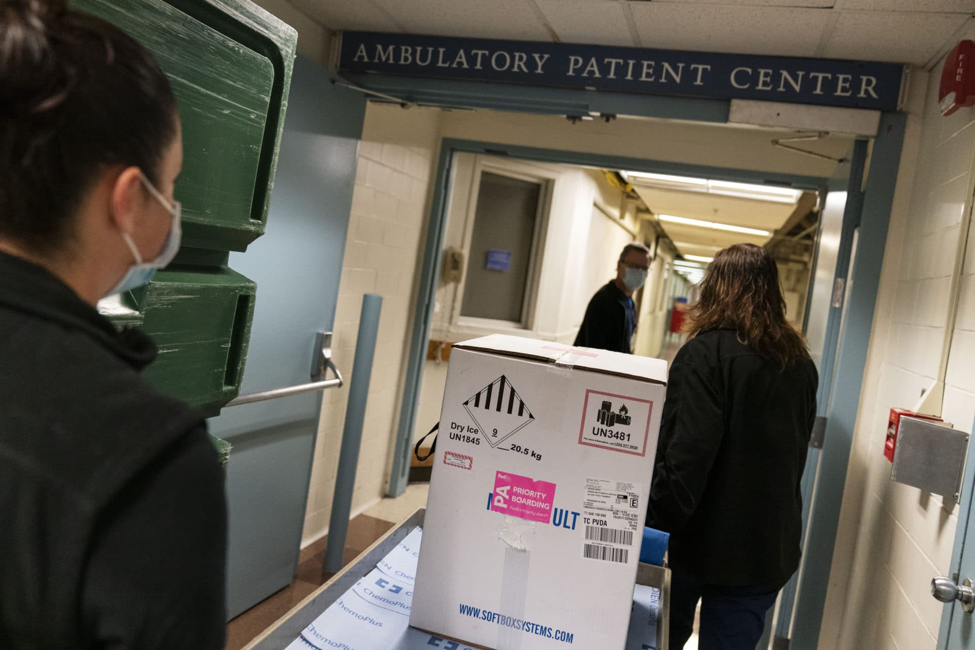 Pharmacists wheel a box containing the Pfizer-BioNTech COVID-19 vaccine to a freezer as it arrives at Rhode Island Hospital in Providence on Monday. (David Goldman/AP)