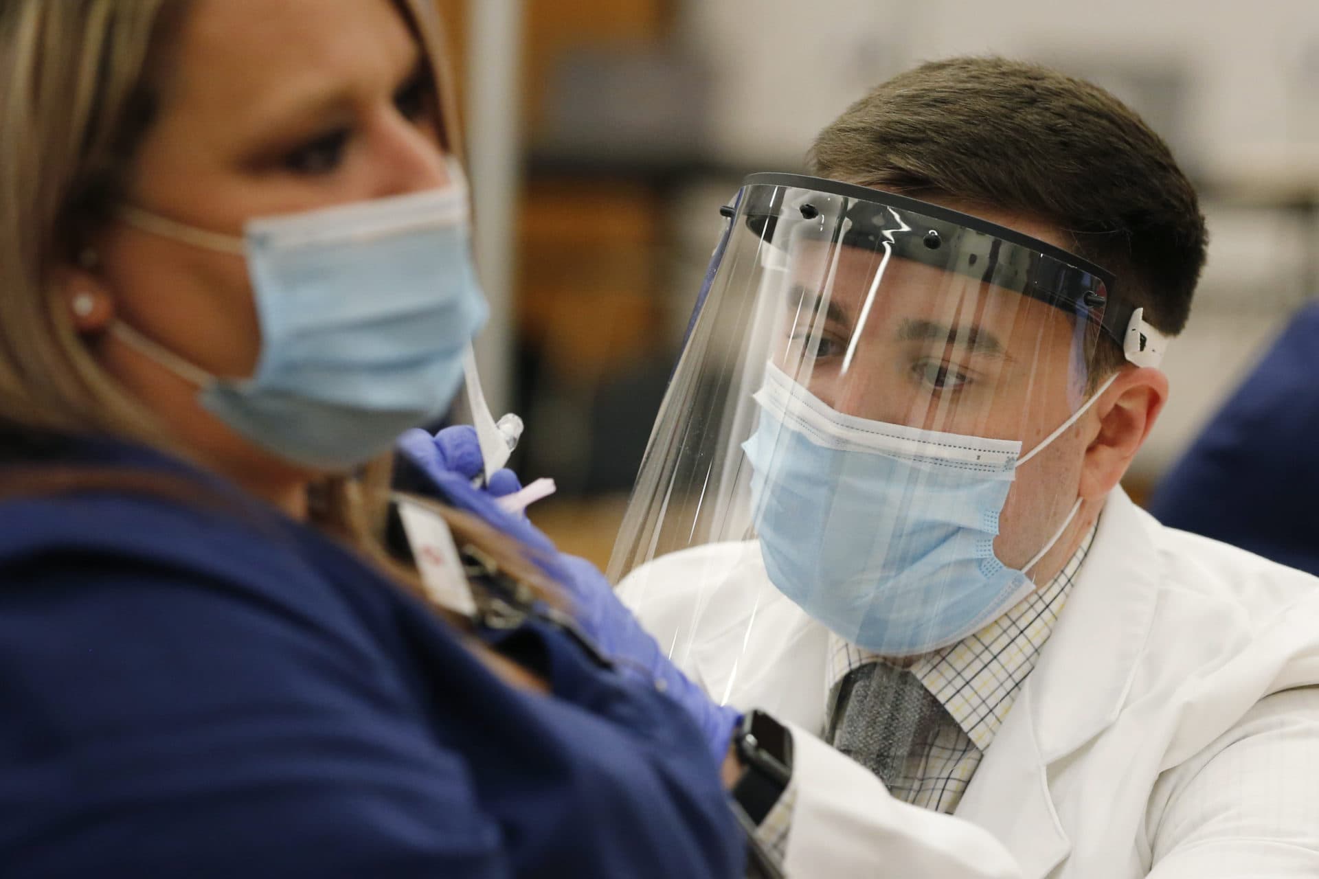 Ohio State employee Cory Coffey, right, administers a Pfizer-BioNTech COVID-19 vaccine in Columbus, Ohio. (Jay LaPrete/AP)