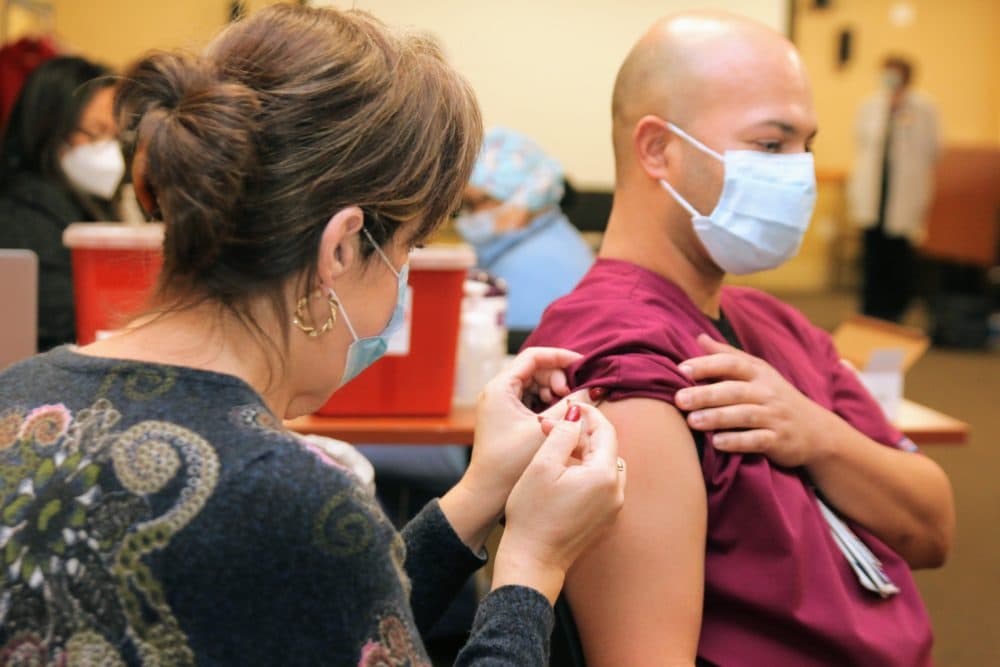 Nurse Christian Barros receives the first dose of Pfizer's COVID-19 vaccine at Charlton Memorial Hospital (Courtesy Southcoast Health)