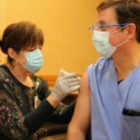 Dr. Dani Hackner, pulmonologist and chief clinical officer for Southcoast Health System, gets his first dose of the Pfizer-developed coronavirus vaccine on Tuesday. (Courtesy Southcoast Health System)