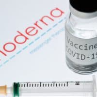 A syringe and a bottle reading "Vaccine COVID-19" next to the Moderna biotech company logo. (Joel Saget/AFP via Getty Images)