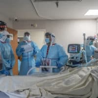 Medical staff members discuss as they check up on a patient in the COVID-19 intensive care unit at the United Memorial Medical Center  on Dec. 4, 2020 in Houston, Texas. (Photo by Go Nakamura/Getty Images)