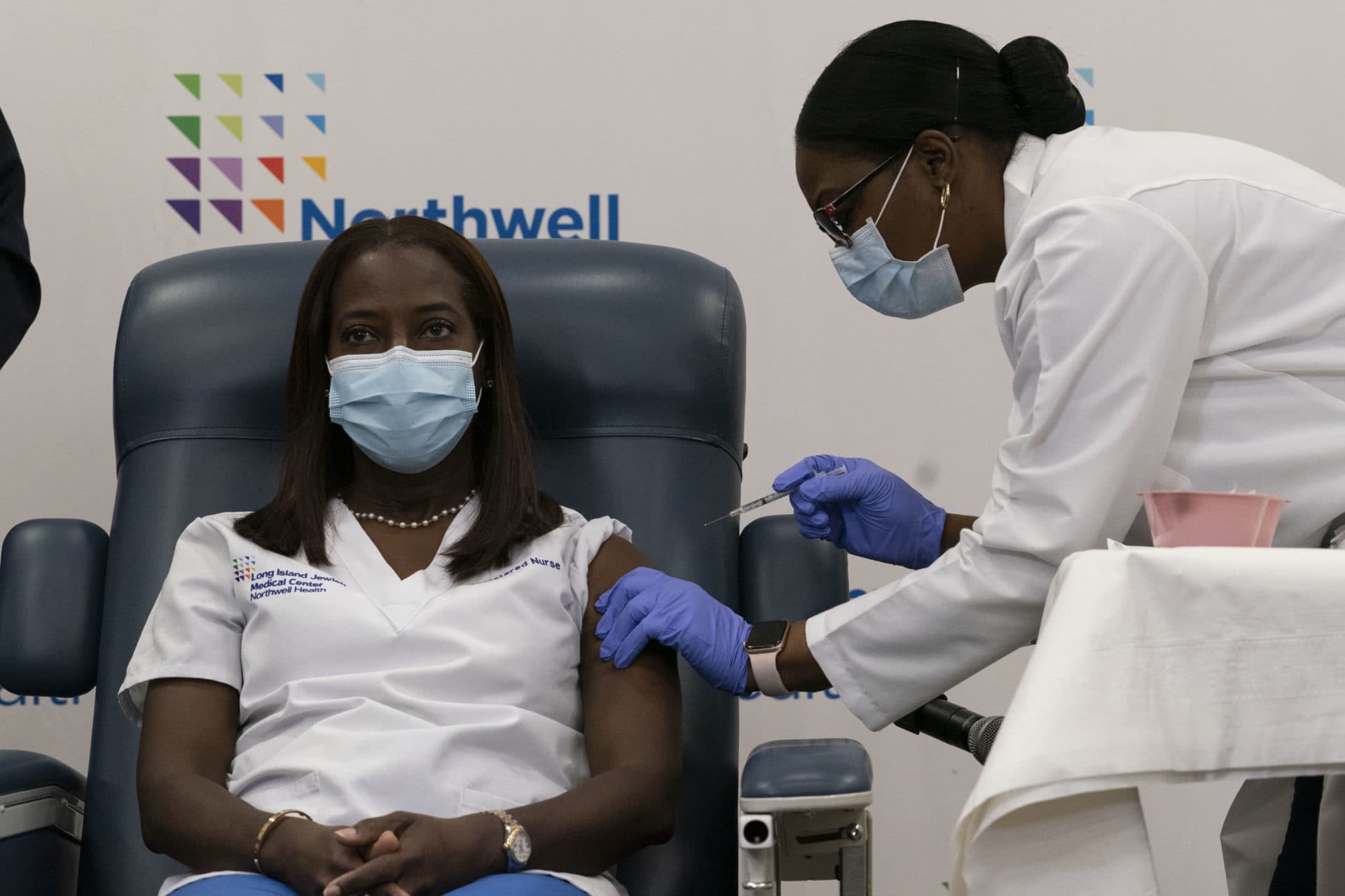 Sandra Lindsay, left, a nurse at Long Island Jewish Medical Center in Queens, New York, is inoculated with the COVID-19 vaccine by Dr. Michelle Chester, on Monday. The rollout of the Pfizer-BioNTech vaccine, the first to be authorized by the Food and Drug Administration, ushers in the biggest vaccination effort in U.S. history. (Mark Lennihan/Getty Images)