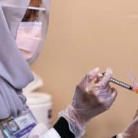 Fetiya Omer, a pharmacist, administers a COVID-19 vaccine to a health care worker at the University Of Washington Medical Center on December 15, 2020 in Seattle, Washington. (David Ryder/Getty Images)
