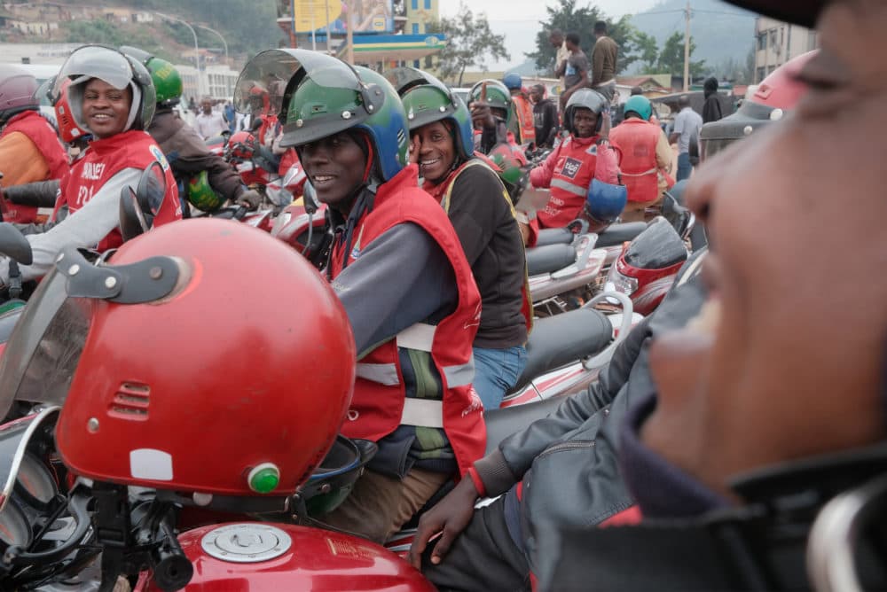 Motorcycle taxis operate in Kigali’s Central Business District. The mototaxi culture has allowed for tens of thousands of Rwandans to become small scale entrepreneurs. Legislation enforces the use of motorcycle helmets by all riders. The government now wants to convert gas mototaxis to electric mototaxis. (Jack Picone)