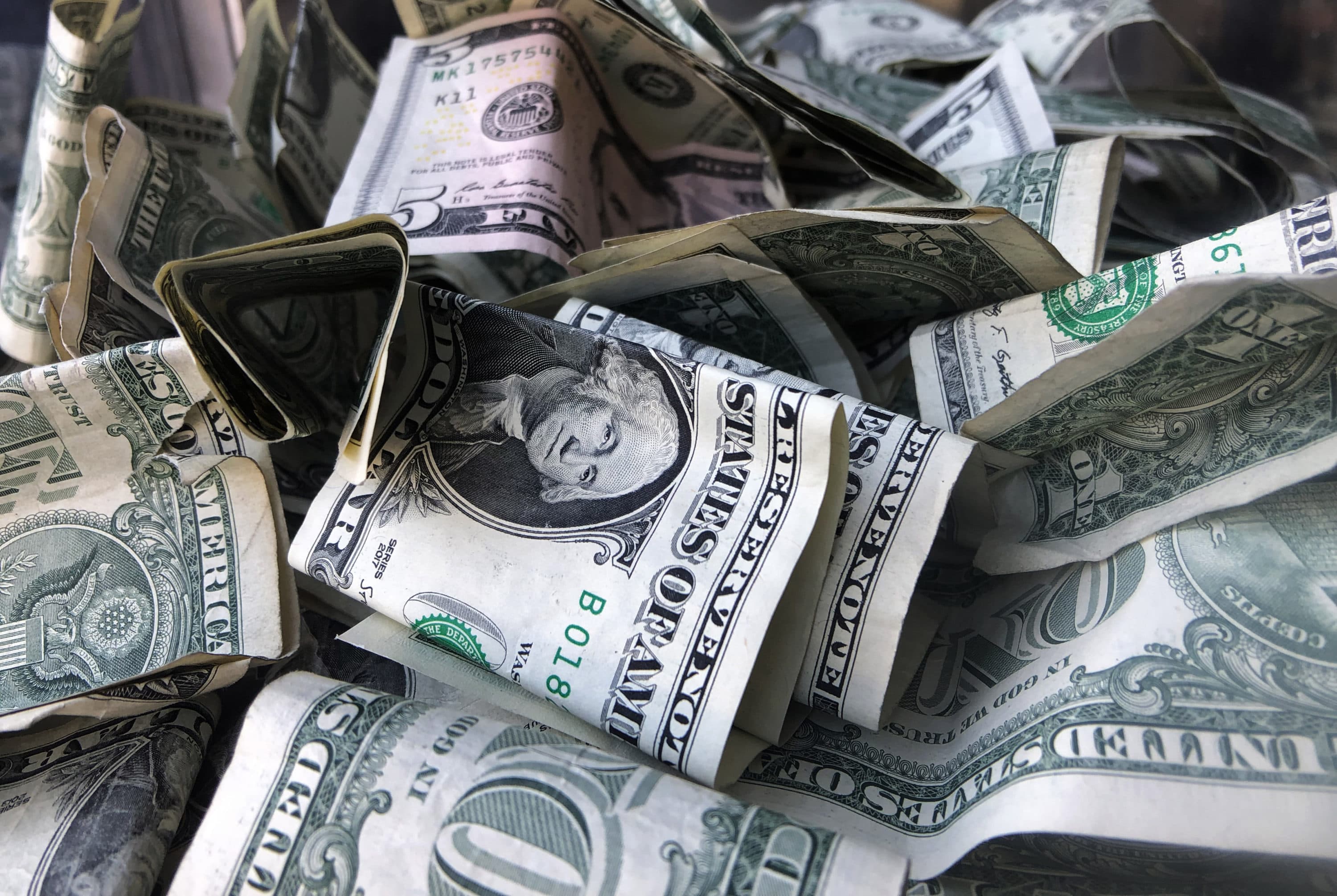 This 2019 file photo shows a tip box filled with U.S. currency in New York. (Mark Lennihan/AP)