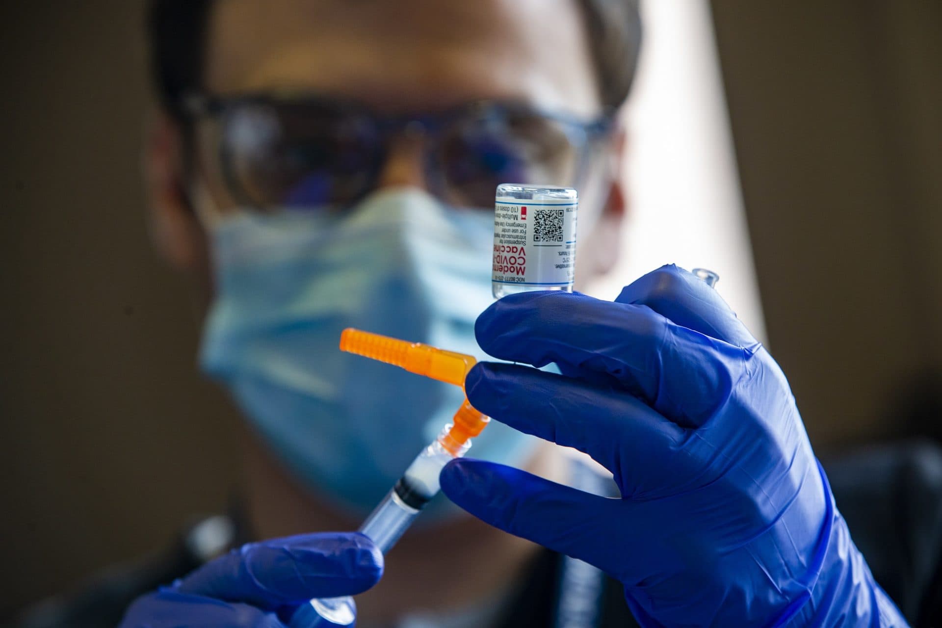 UMass Medical School student Timothy Winn prepares doses of the Moderna COVID-19 vaccine at the Hotel Grace homeless shelter in Worcester. (Jesse Costa/WBUR)