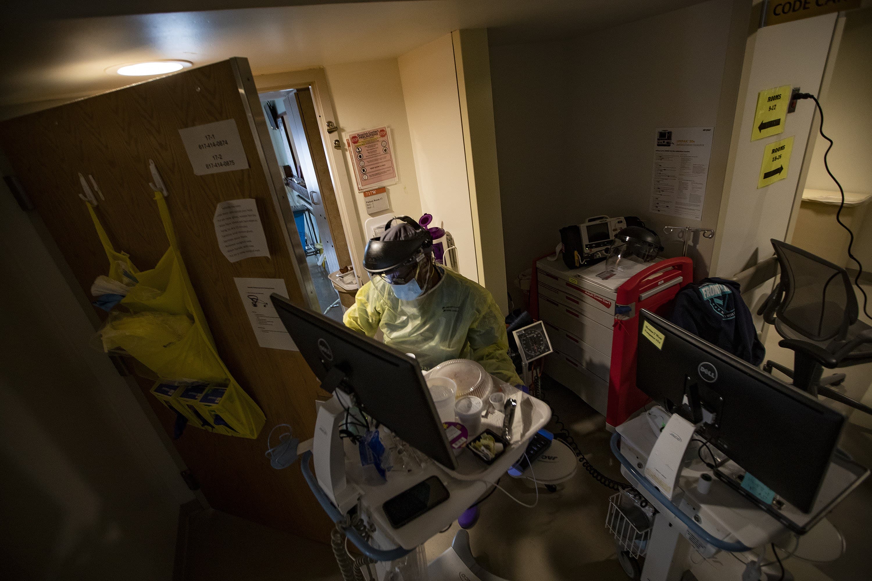 Boston Medical Center registered nurse Ellen Stephenson prepares to enter a room of a COVID-19 patient with supplies. (Jesse Costa/WBUR)