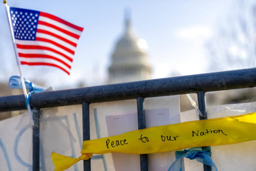 A ribbon reading "Peace to Our Nation" is visible at a memorial for Capitol Police Officer Brian D. Sicknick near the Capitol Building on Capitol Hill in Washington, Thursday, Jan. 14, 2021. (AP Photo/Andrew Harnik)