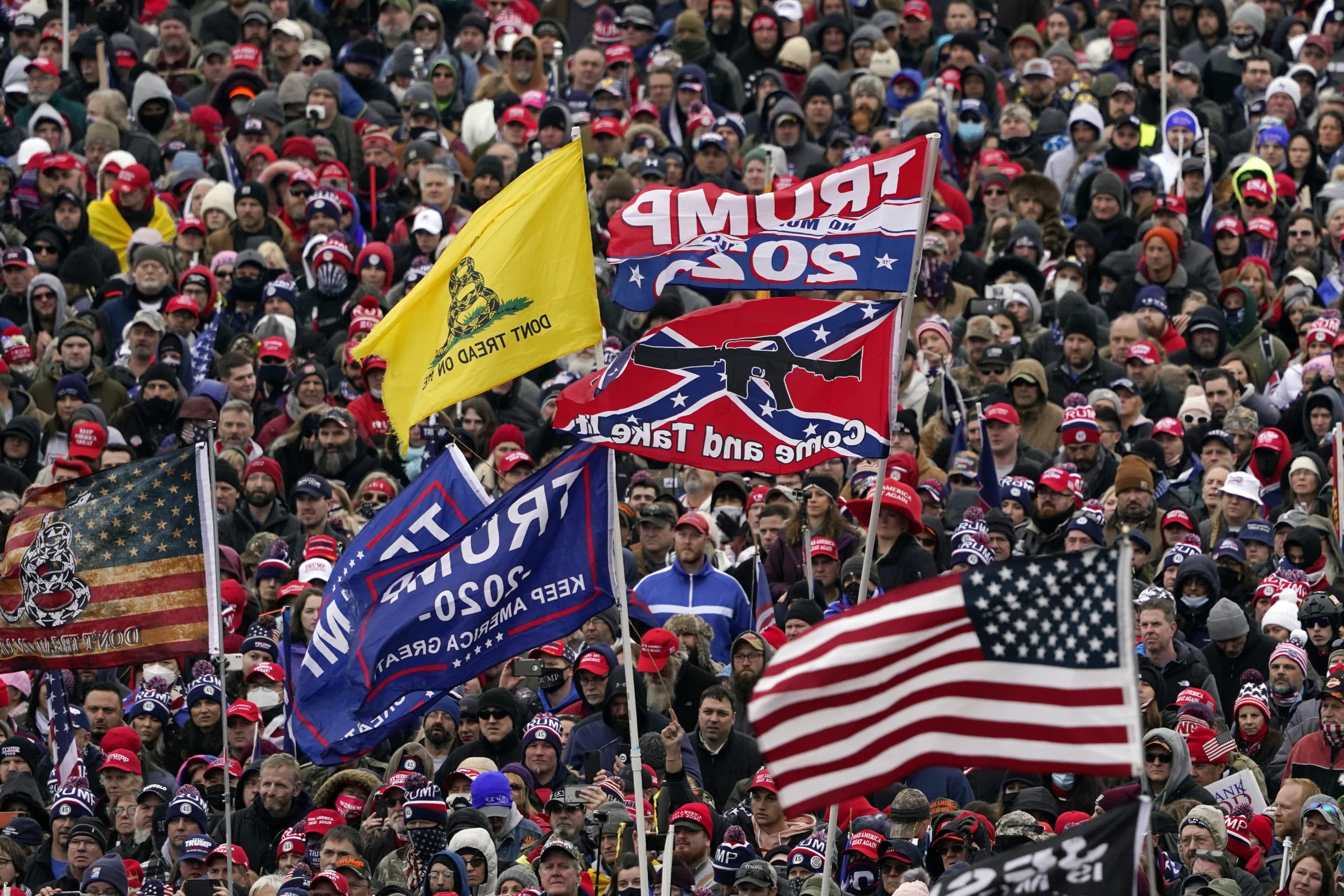In this Jan. 6, 2021 photo, supporters listen as President Donald Trump speaks as a Confederate-themed and other flags flutter in the wind during a rally in Washington. (Evan Vucci/AP)
