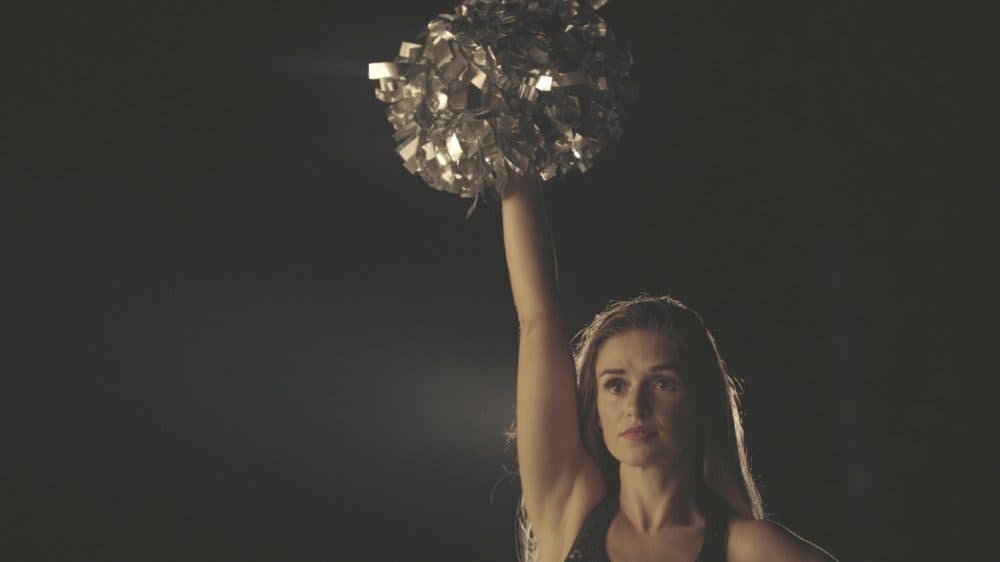 Lacy Thibodeaux standing with pom poms in the air. (Photo by Yu Gu)