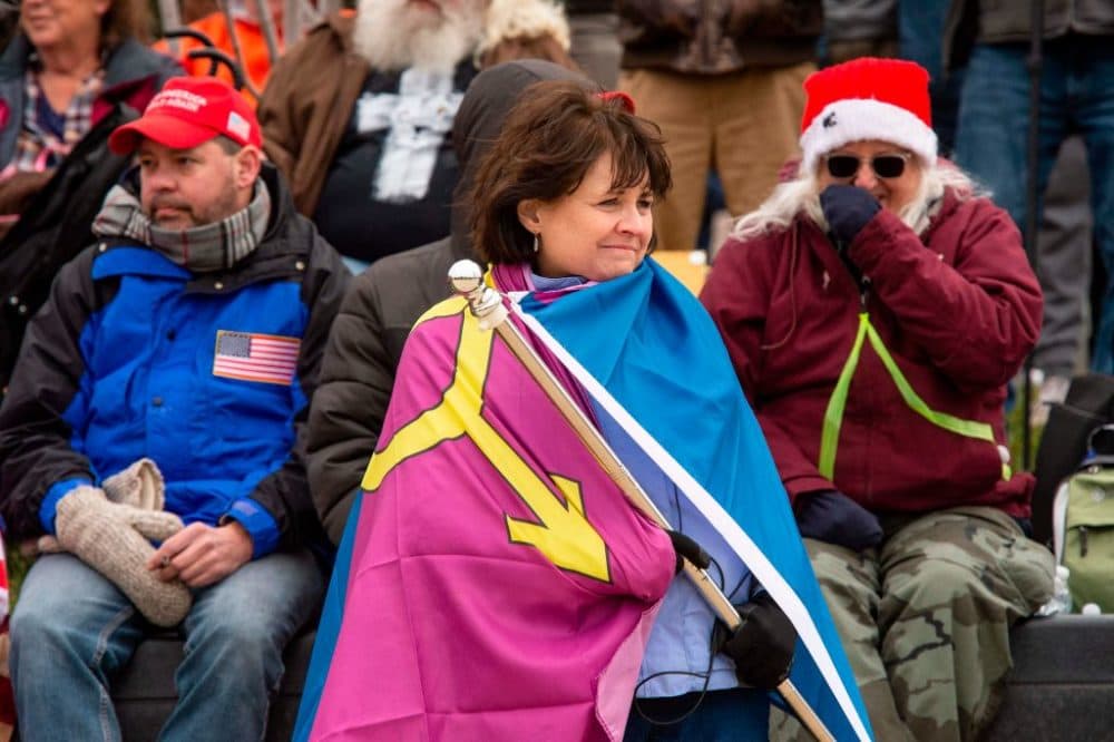 Natick Town Meeting member Suzanne Ianni wraps herself in the group called Super Happy Fun America's so-called "Straight Pride" flag as she and other supporters of President Trump wait for him to address them during a rally in Washington, D.C. on Jan. 6. (Joseph Prezioso/AFP via Getty Images)