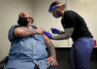 Inmate Christian Millett, of Worcester, gets the first of two COVID-19 vaccine shots administered by Alyssa Dobbs, an LPN contractor, in the medical department at the Worcester County Jail and House of Corrections in West Boylston on Jan 22, 2021. (David L. Ryan/The Boston Globe via Getty Images)