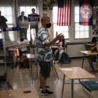 Honors Civics teacher Mike Brown discusses the upcoming U.S. Presidential election with masked students on the first day of school at Stamford High School on September 08, 2020 in Stamford, Connecticut. (John Moore/Getty Images)