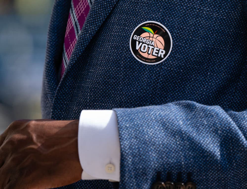 A "Georgia Voter" sticker is seen on the jacket of Democratic U.S. Senate candidate Raphael Warnock after he cast his ballot during early voting on October 21, 2020 in Atlanta, Georgia. (Elijah Nouvelage/Getty Images)