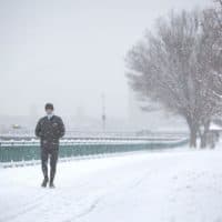 A runner makes his way along Memorial Drive during a snowstorm on Jan. 27, 2021. (Robin Lubbock/WBUR)