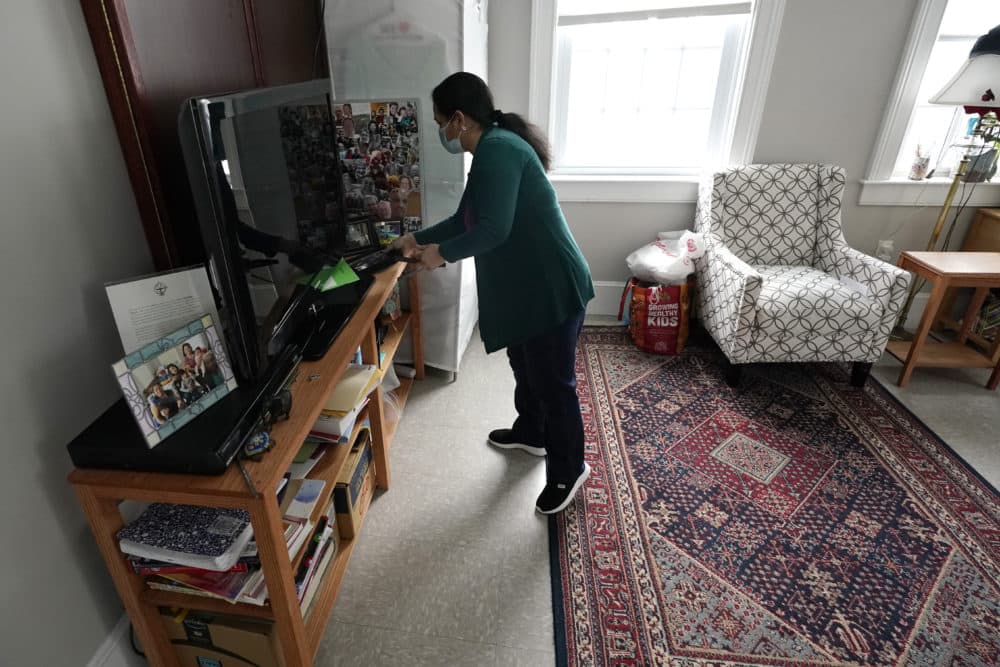 Maria Macario looks at her personal belongings in her temporary home at the First Parish church. (Charles Krupa/AP)