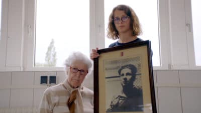 Colette Marin-Catherine (left) with Lucie Fouble with a picture of Colette's brother, Jean-Pierre, who died in Mittelbau-Dora concentration in Germany. (Courtesy of The Guardian)