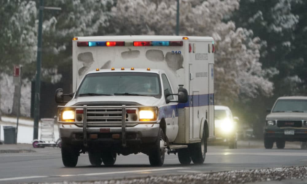 An ambulance roars along westbound West Colfax Avenue through traffic in downtown Denver. (David Zalubowski/AP)
