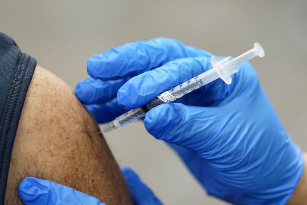 A healthcare worker receives a second Pfizer-BioNTech COVID-19 vaccine shot. (Paul Sancya/AP)