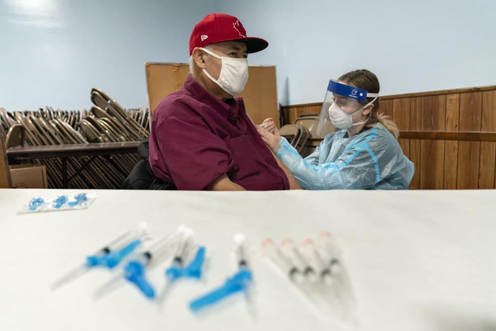 Mario Valdez, 62, receives his first shot of a vaccine at a clinic in Central Falls, Jan. 9, 2021. "I feel happy," the 62-year-old school bus driver said. (David Goldman/AP)