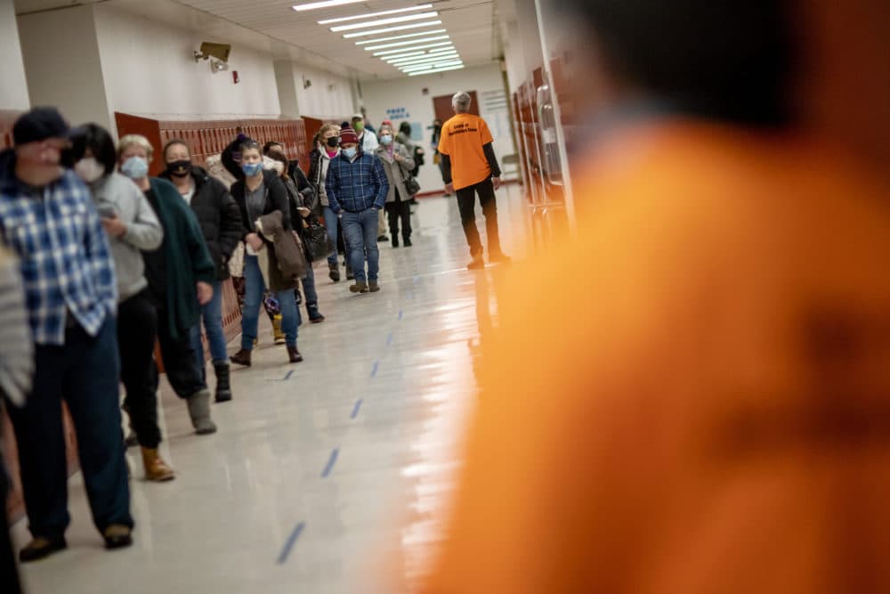 People line up for vaccines at a clinic in Central Falls, R.I., Feb. 20, 2021. Nearly a third of adults in the city have received at least one dose of vaccine, according to state data. (David Goldman/AP)