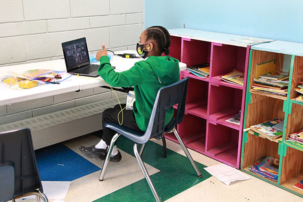 A six-year-old gives the thumbs up to his teacher in his virtual classroom at the Roxbury YMCA in Boston on Sept. 21, 2020. (Suzanne Kreiter/The Boston Globe via Getty Images)