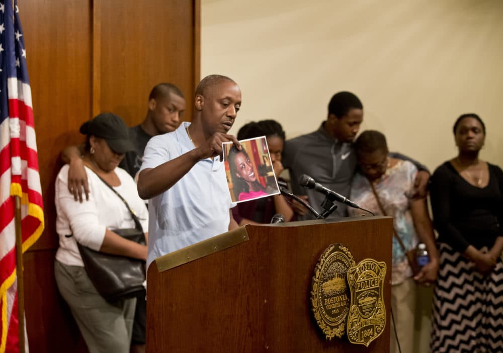In this file photo from 2014, Ian Jaffier holds a picture of his daughter, Dawnn Jaffier, 26, who was fatally shot on Blue Hill Avenue that year. (Matthew J. Lee/The Boston Globe via Getty Images)