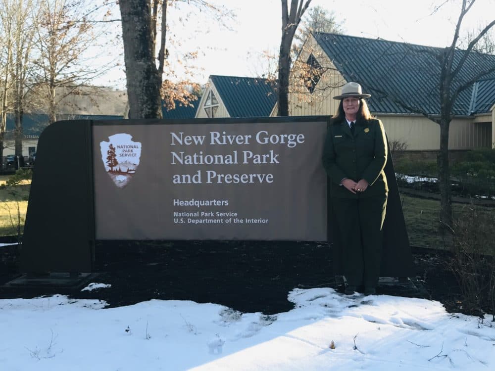Superintendent Lizzie Watts stands in front of the new sign at park headquarters. (Courtesy)