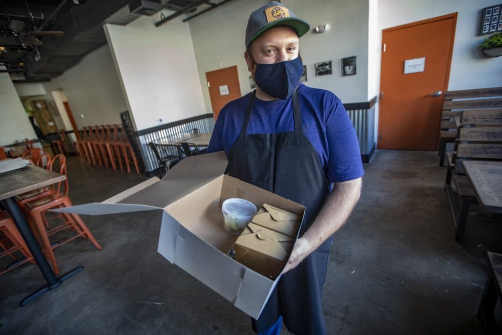 Brato co-founder and executive chef Jonathan Gilman holds a "Hell Night" food box. (Jesse Costa/WBUR)