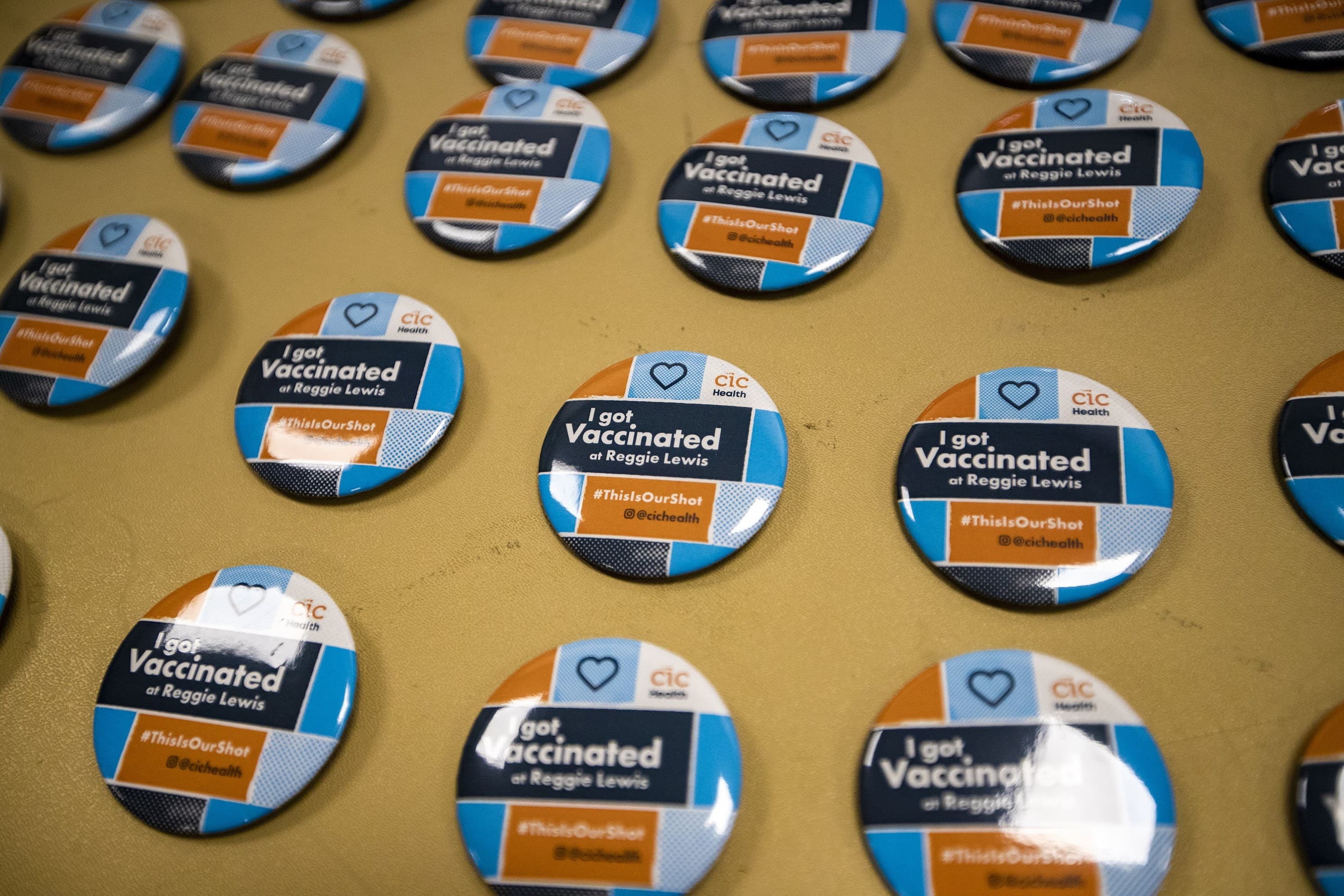 “I got vaccinated” buttons on a table for recipients of the Pfizer BioNTech vaccine to take on their way out of the Reggie Lewis Center. (Jesse Costa/WBUR)