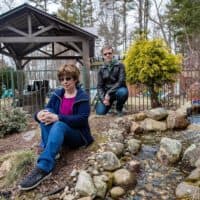 Lee Brooks lost her son to leukemia, and Brian Dellascio had Hodgkin lymphoma as a teen. They're pictured outside Brooks' Wilmington home. (Jesse Costa/WBUR)