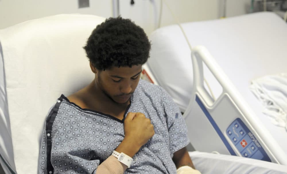 Malik Koval sits in a hospital chair before his arraignment Tuesday, July 31, 2018, at Brigham & Women's Hospital in Boston. (Merrily Cassidy/The Cape Cod Times via AP, Pool)