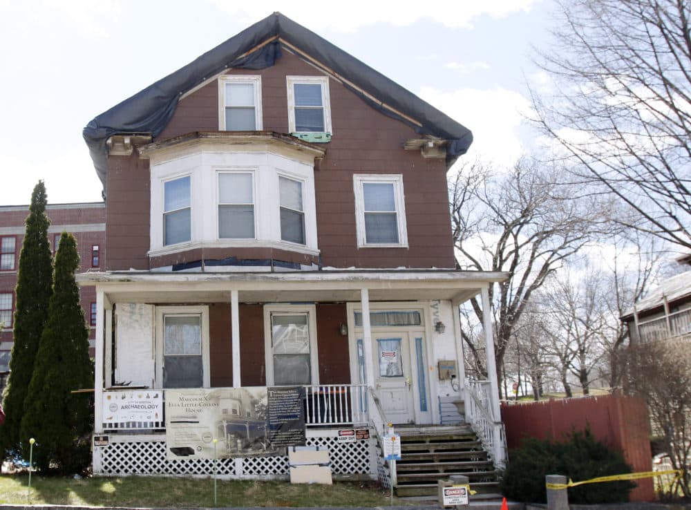 In this 2016, file photo, signs call attention to the house where slain African-American leader Malcolm X spent part of his childhood in the Roxbury neighborhood of Boston. According to the National Park Service the house was added to the National Register of Historic Places in February 2021. (Bill Sikes/AP File)