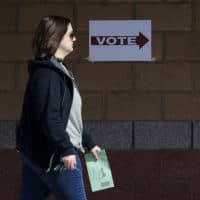 An Arizona voter delivers her mail-in ballot at a polling station for the Arizona presidential preference election in Phoenix. (Matt York/AP Photo)