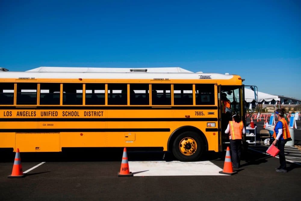 Vaccination site workers board a school bus transporting education workers as it arrives at a mass vaccination site on March 1, 2021 in Inglewood, California. The vaccination site is part of a plan from the Los Angeles Unified School District (LAUSD) and State of California to reopen all district elementary schools by mid-April. (Patrick T. Fallon/AFP/Getty Images)