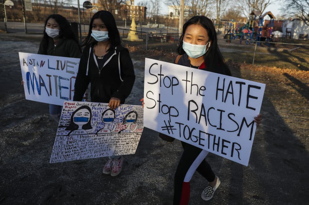 Children carry "stop the hate" and "Asian lives matter" as they walk around Clemente Park in Lowell, Mass. during a vigil held for the victims of the shooting spree in Atlanta at Clemente Park on March 17, 2021. (Erin Clark/The Boston Globe via Getty Images)