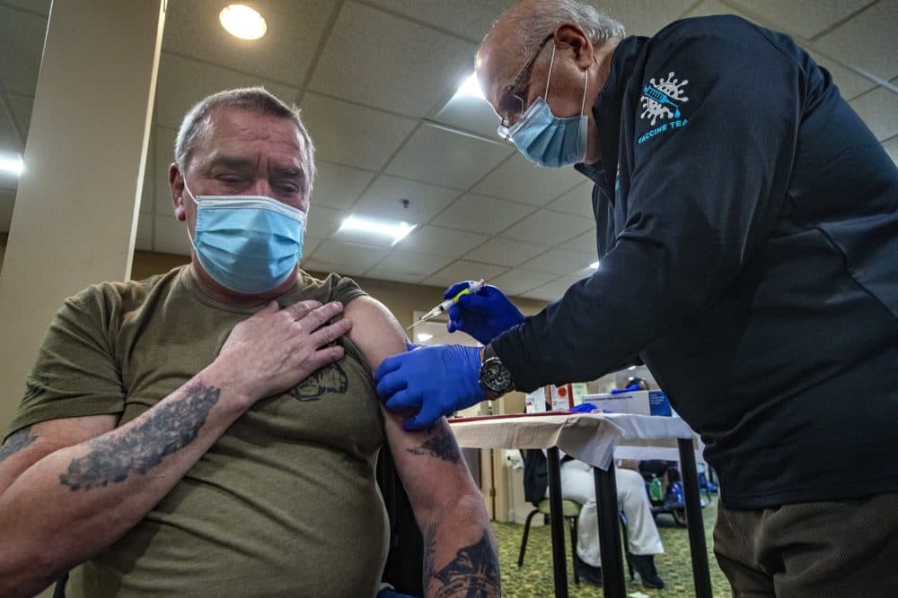 Dr. Abraham Haddad administers the second dose of the Moderna COVID-19 vaccine shot to Worcester resident Wayne Goodrich at the Coes Pond Senior Apartments by the Umass Medical Mobile Vaccine unit. (Jesse Costa/WBUR)