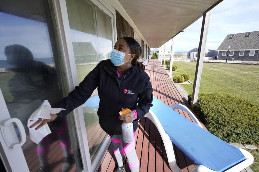 Worker Jennifer Porter, of Hyannis, Mass., cleans windows, April 6, 2021, at Red Jacket Resorts, in Yarmouth. (Steven Senne/AP)
