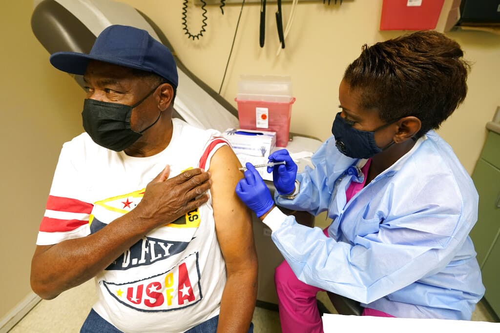 Wilbert Marshall, 71, looks away while receiving the COVID-19 vaccine from Melissa Banks, right, a nurse at the Aaron E. Henry Community Health Service Center in Clarksdale, Miss., Wednesday, April 7, 2021. Marshall was among a group of seniors from the Rev. S.L.A. Jones Activity Center for the Elderly who received their vaccinations. The Mississippi Department of Human Services is in the initial stages of teaming up with community senior services statewide to help older residents get vaccinated. (AP Photo/Rogelio V. Solis, File)