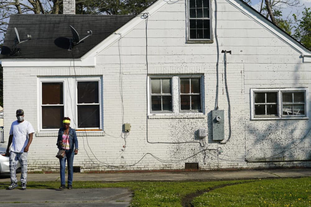 Residents survey the scene where at least one law enforcement officer with a sheriff's department in North Carolina shot and killed a man while executing a search warrant in Elizabeth City, N.C. (Gerry Broome/AP)